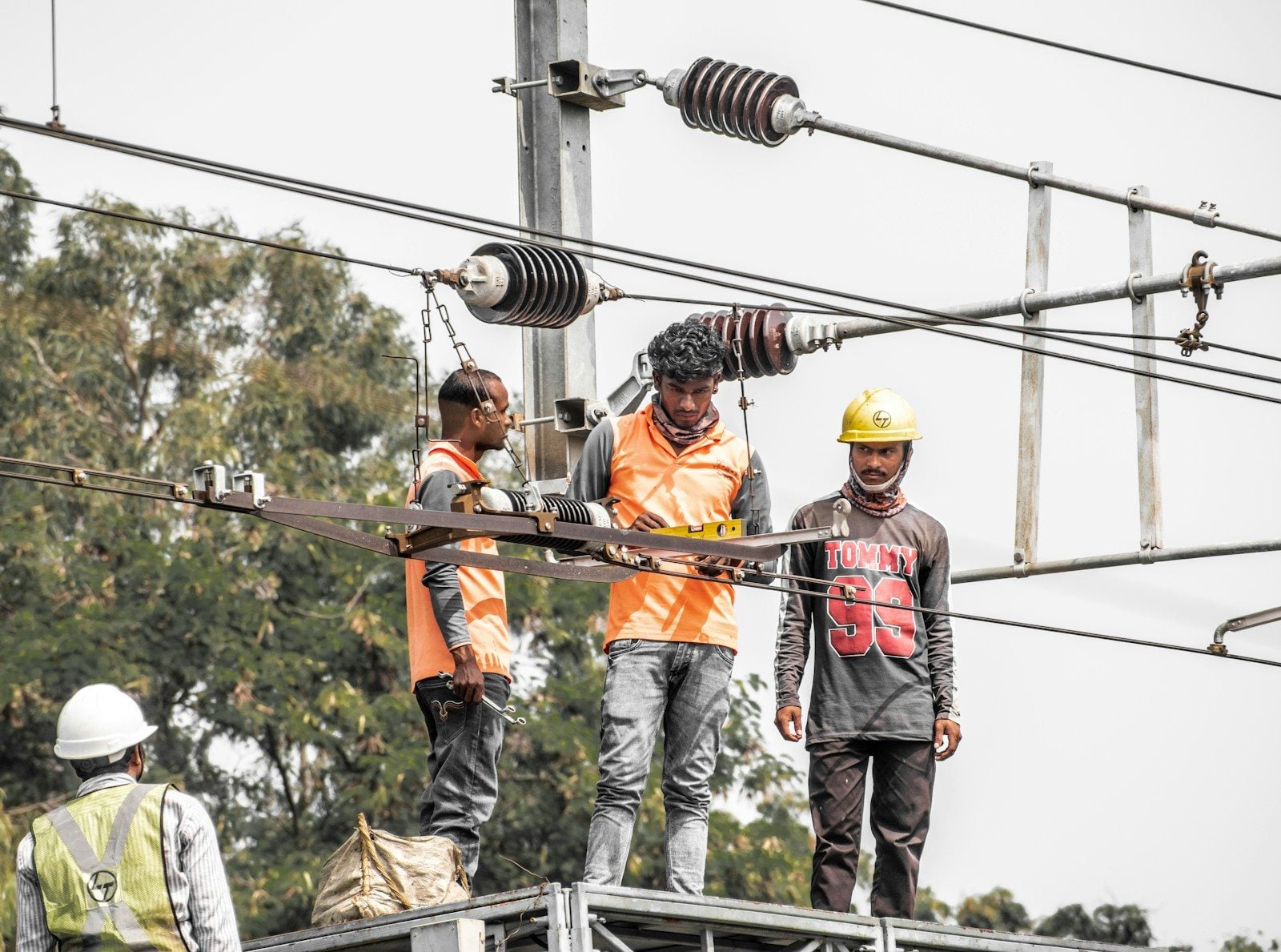 a group of men standing on top of a power line