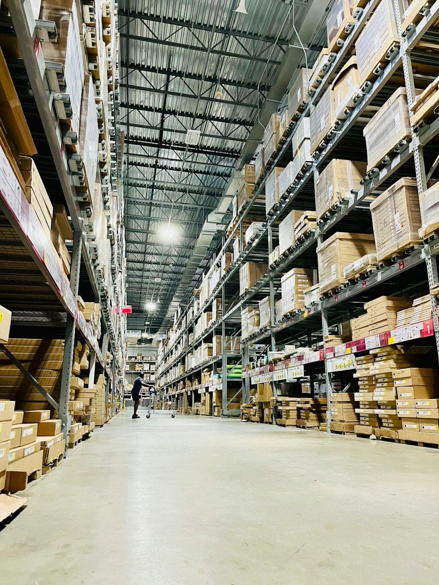 Tall shelves filled with cardboard boxes in a warehouse aisle