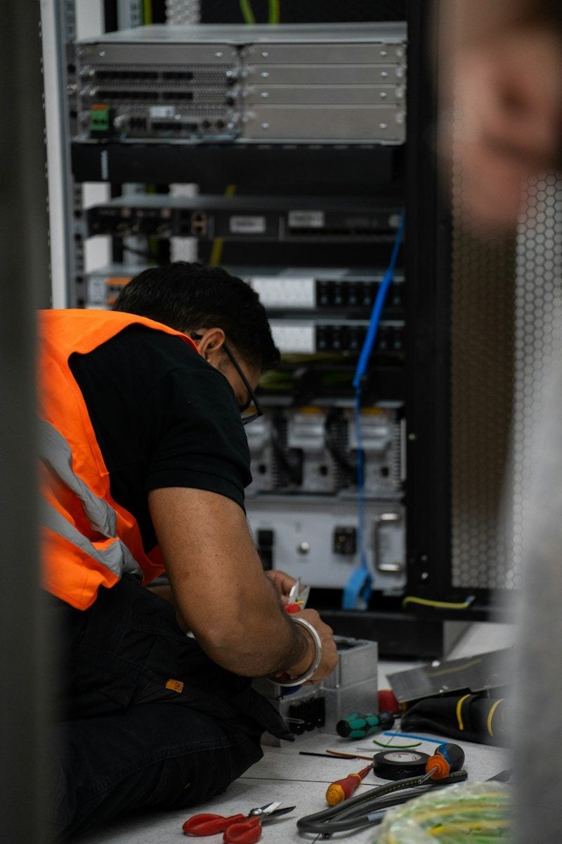 Technician working on server equipment with tools