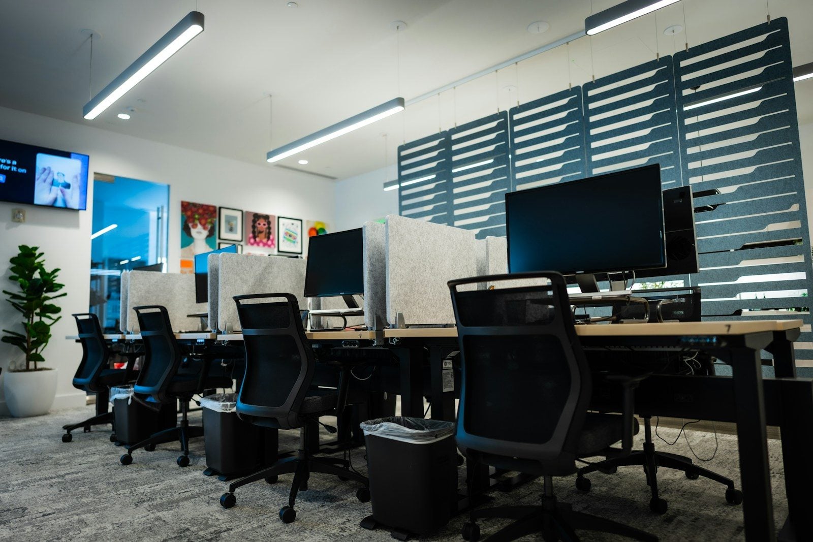 Modern empty office with multiple desks, chairs, and computers